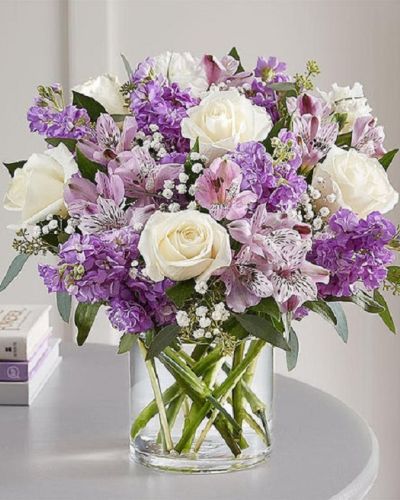 Lovely memories are made with thoughtful gifts for the ones we care about. Our charming bouquet is loosely gathered with a medley of lavender & white blooms. Hand-designed inside a clear cylinder vase with cascading greenery all around, it’s a wonderful way to express the sentiments you have inside your heart.